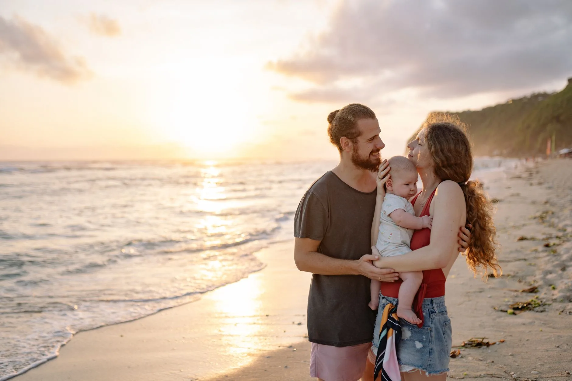 Parents avec un bébé et une poussette sur une plage de sable blanc au Cap-Vert